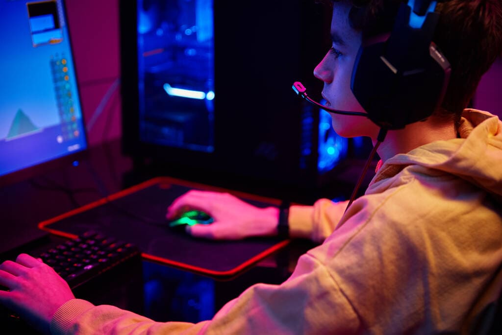 Дитина грає у відеоігри. Юний ґеймер у ігровому клубі